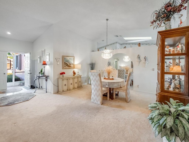 dining area with baseboards, light colored carpet, an inviting chandelier, and vaulted ceiling