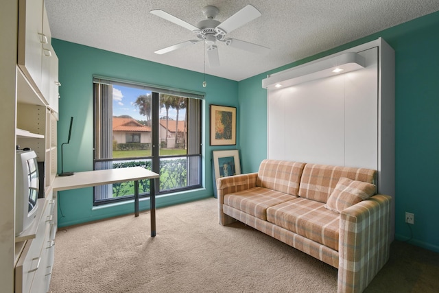 living room featuring carpet flooring, a textured ceiling, and a ceiling fan