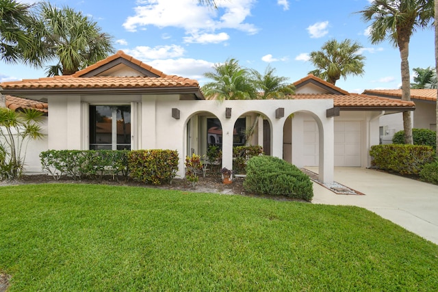 mediterranean / spanish-style home featuring stucco siding, concrete driveway, a front yard, a garage, and a tiled roof