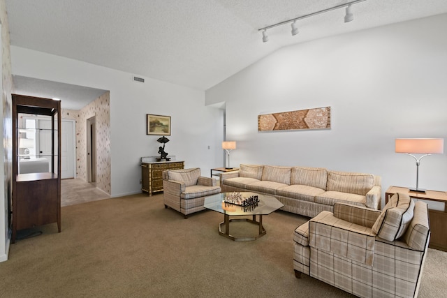 carpeted living room with visible vents, rail lighting, a textured ceiling, and lofted ceiling