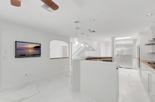 kitchen featuring visible vents, ventilation hood, stainless steel built in refrigerator, white cabinets, and marble finish floor