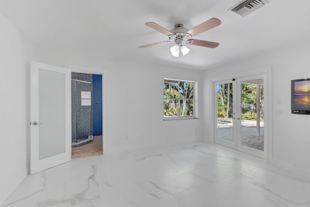 empty room with visible vents, marble finish floor, a ceiling fan, french doors, and baseboards