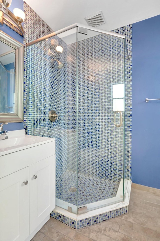 full bathroom with vanity, a shower stall, visible vents, and tile patterned flooring