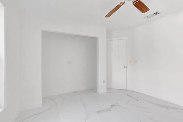 unfurnished room with visible vents, baseboards, marble finish floor, and ceiling fan