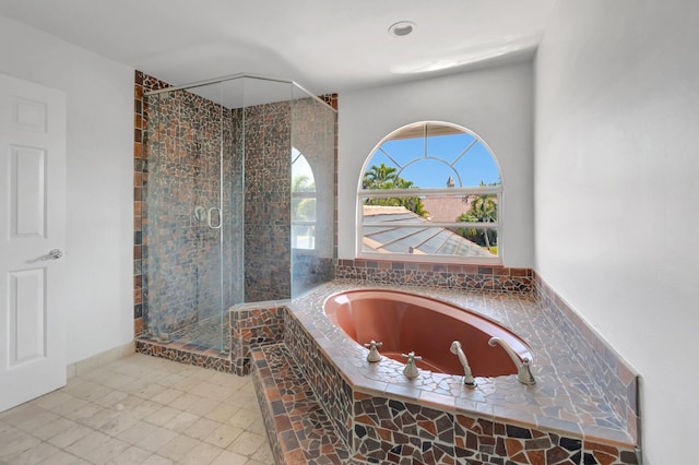 bathroom featuring a stall shower and a bath