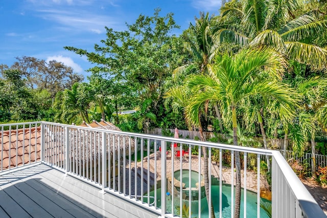 wooden deck with a jacuzzi and a fenced backyard