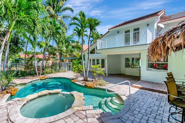 view of swimming pool with a patio area, a pool with connected hot tub, french doors, and a fenced backyard