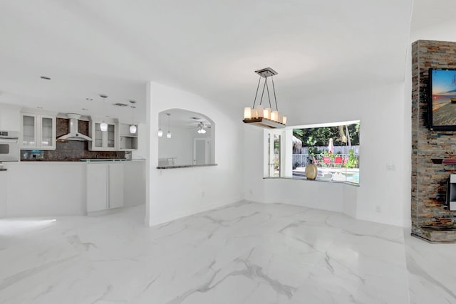 unfurnished living room featuring marble finish floor and ceiling fan