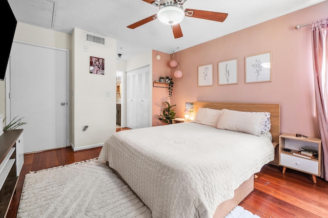 bedroom featuring a closet, visible vents, a ceiling fan, and wood finished floors