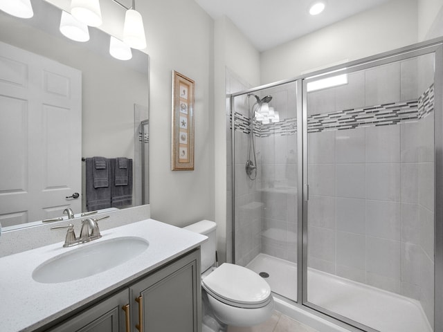 full bath featuring toilet, a stall shower, and vanity