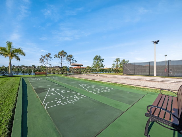 view of community with shuffleboard and fence
