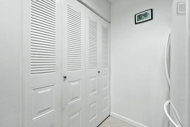 corridor with light tile patterned floors and baseboards