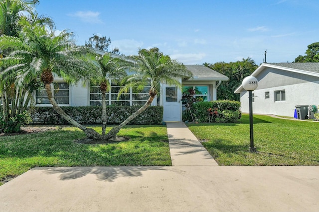 view of front of home with stucco siding and a front yard