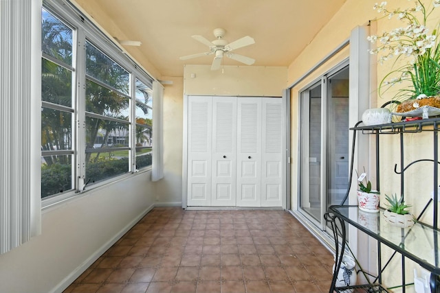 unfurnished sunroom with a ceiling fan