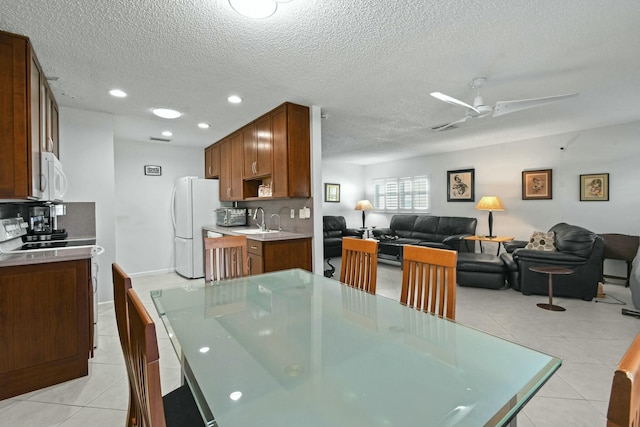 dining area featuring light tile patterned floors, a textured ceiling, and ceiling fan