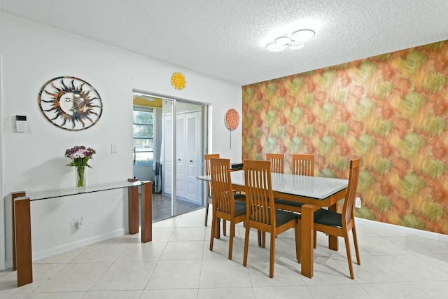 dining area featuring wallpapered walls, light tile patterned floors, baseboards, and a textured ceiling