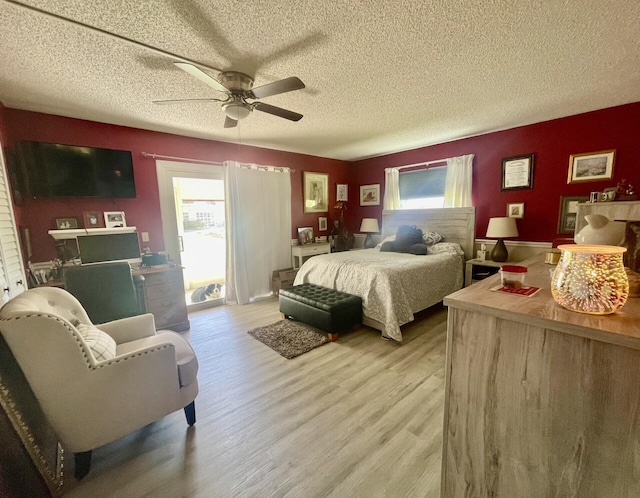 bedroom featuring a textured ceiling, light wood-type flooring, and ceiling fan