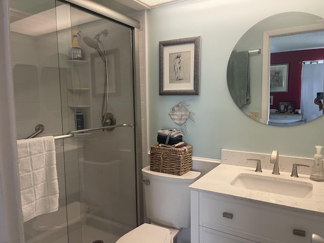 full bath with toilet, vanity, and a shower stall