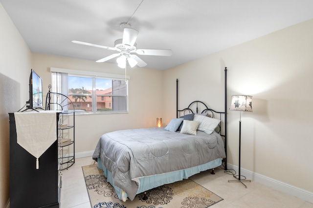 bedroom with light tile patterned floors, a ceiling fan, and baseboards