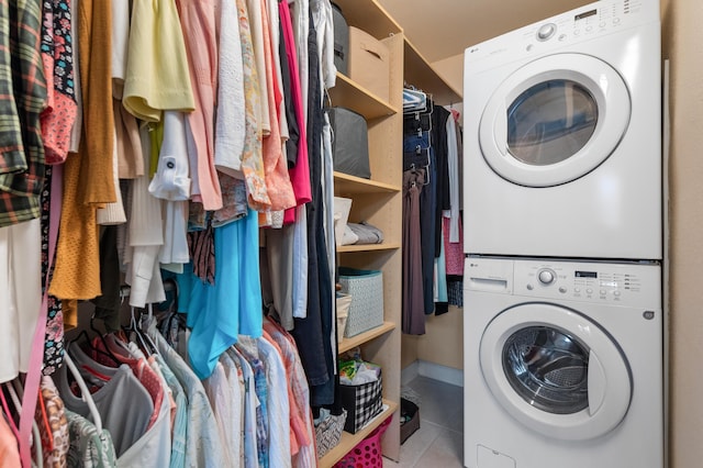 laundry area with tile patterned floors, laundry area, and stacked washer / dryer