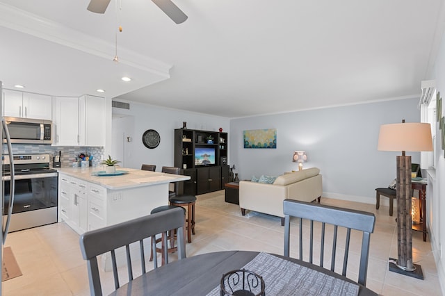 kitchen featuring a peninsula, light tile patterned floors, tasteful backsplash, and appliances with stainless steel finishes