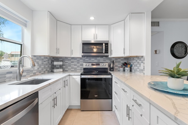 kitchen with visible vents, a sink, stainless steel appliances, white cabinets, and light tile patterned floors