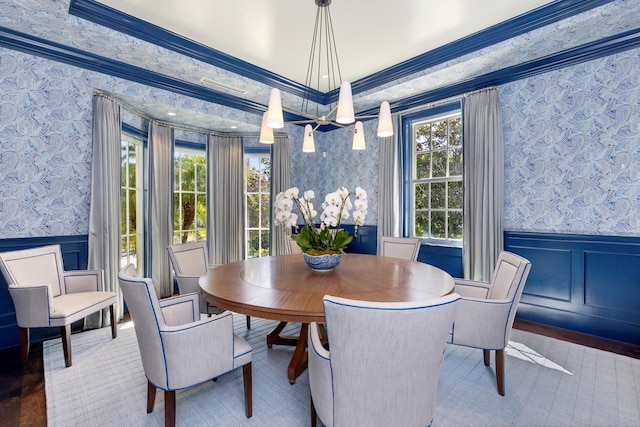 dining area with ornamental molding, wainscoting, and wallpapered walls