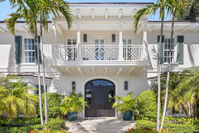 doorway to property with stucco siding and a balcony