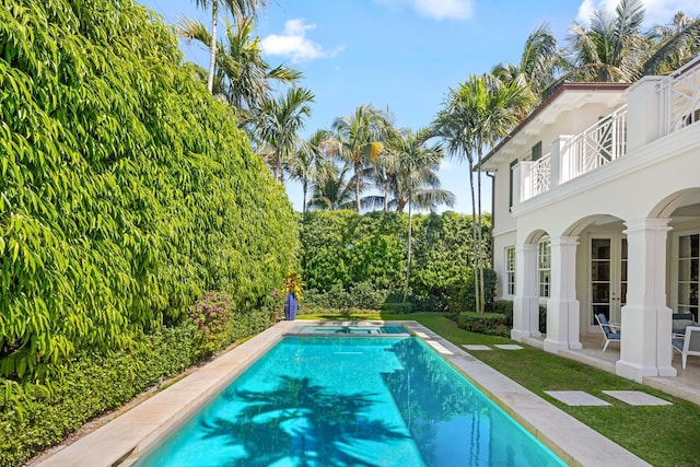 outdoor pool with a patio and a lawn