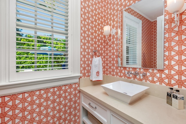 bathroom featuring wallpapered walls, vanity, and ornamental molding