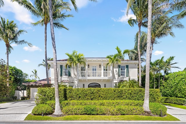 mediterranean / spanish house featuring stucco siding, driveway, and a balcony