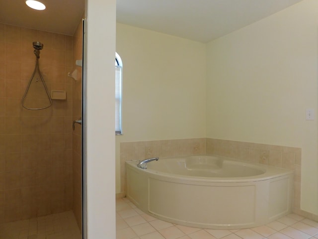 full bath featuring tile patterned flooring, a bath, and a stall shower