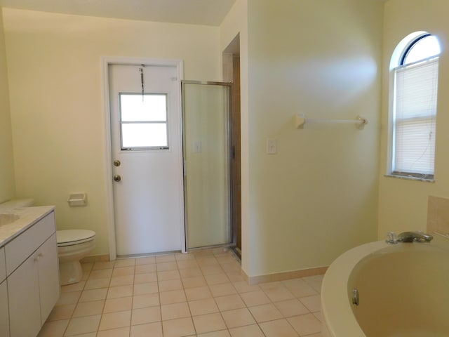 bathroom featuring vanity, a shower stall, a garden tub, and tile patterned floors