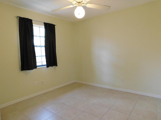 spare room with light tile patterned floors, baseboards, and ceiling fan