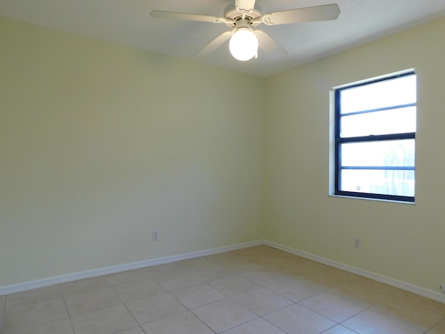 spare room with light tile patterned floors, baseboards, and ceiling fan