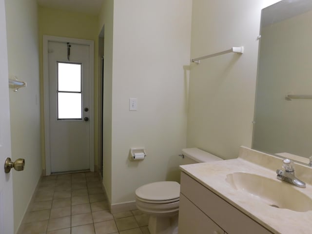 bathroom featuring vanity, tile patterned floors, toilet, and baseboards