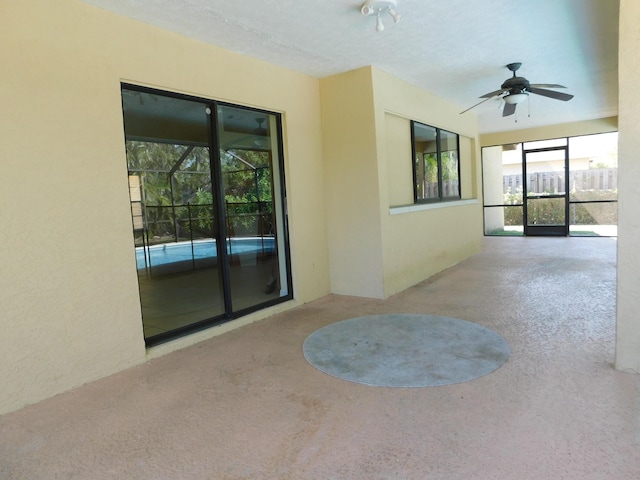 unfurnished sunroom with ceiling fan