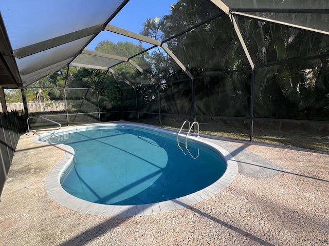 pool with a patio, a lanai, and fence