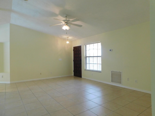 empty room with light tile patterned floors, visible vents, baseboards, and ceiling fan