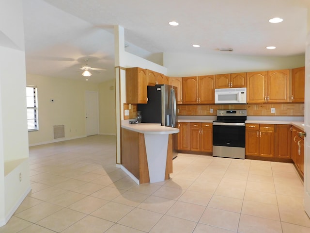 kitchen with visible vents, light countertops, light tile patterned floors, decorative backsplash, and appliances with stainless steel finishes