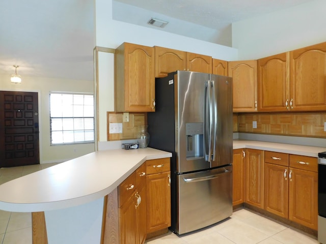 kitchen featuring visible vents, a peninsula, stainless steel fridge with ice dispenser, light countertops, and decorative backsplash