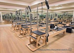 exercise room with a tray ceiling and wood finished floors