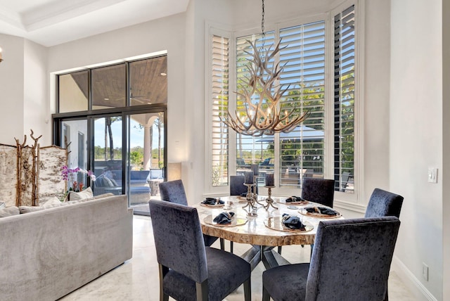 dining area featuring baseboards and a chandelier