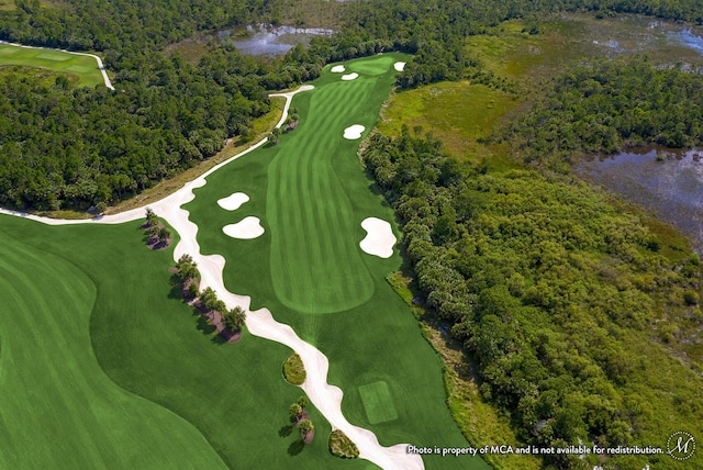 birds eye view of property with golf course view, a view of trees, and a water view