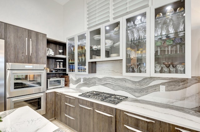 kitchen featuring light stone counters, modern cabinets, and stainless steel appliances