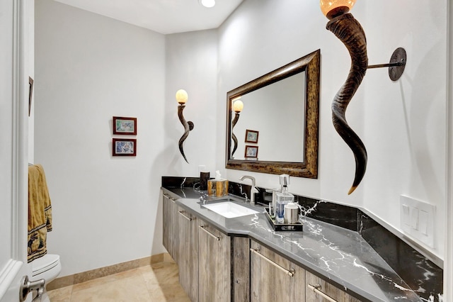 bathroom featuring tile patterned flooring, toilet, vanity, and baseboards