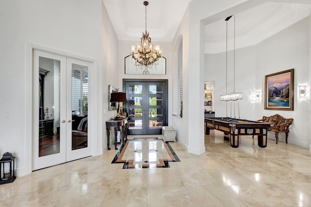 foyer entrance featuring french doors, a towering ceiling, and pool table