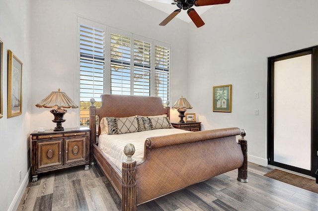 bedroom with baseboards, wood finished floors, and a ceiling fan