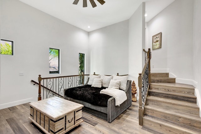 living room with baseboards, ceiling fan, recessed lighting, a towering ceiling, and wood finished floors