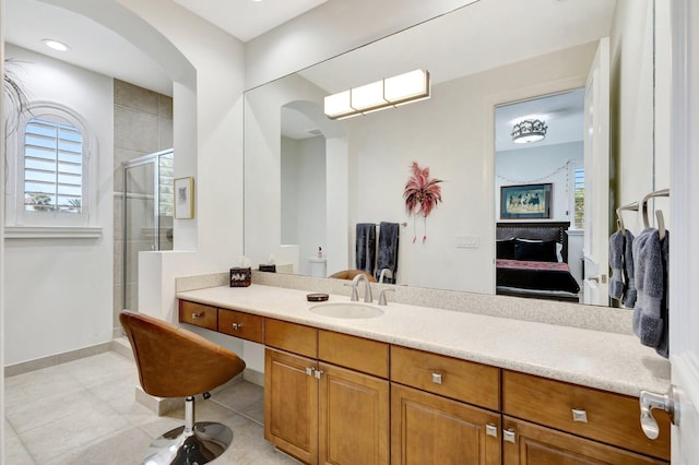 full bath with vanity, baseboards, a stall shower, tile patterned floors, and connected bathroom